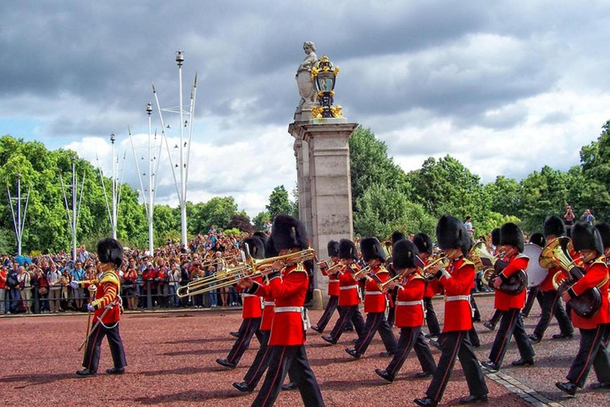 una banda de música amb uniforme vermell davant d'un monument