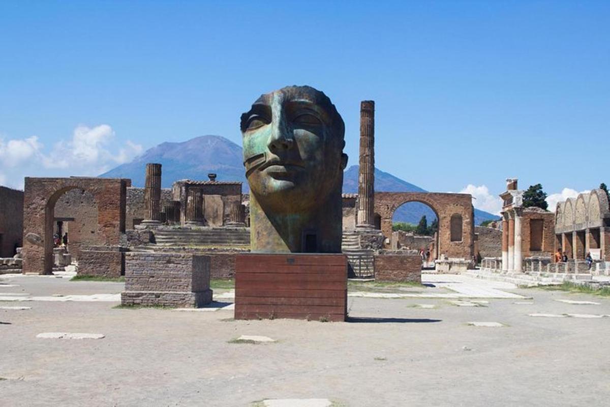 a large statue of a face in front of ruins