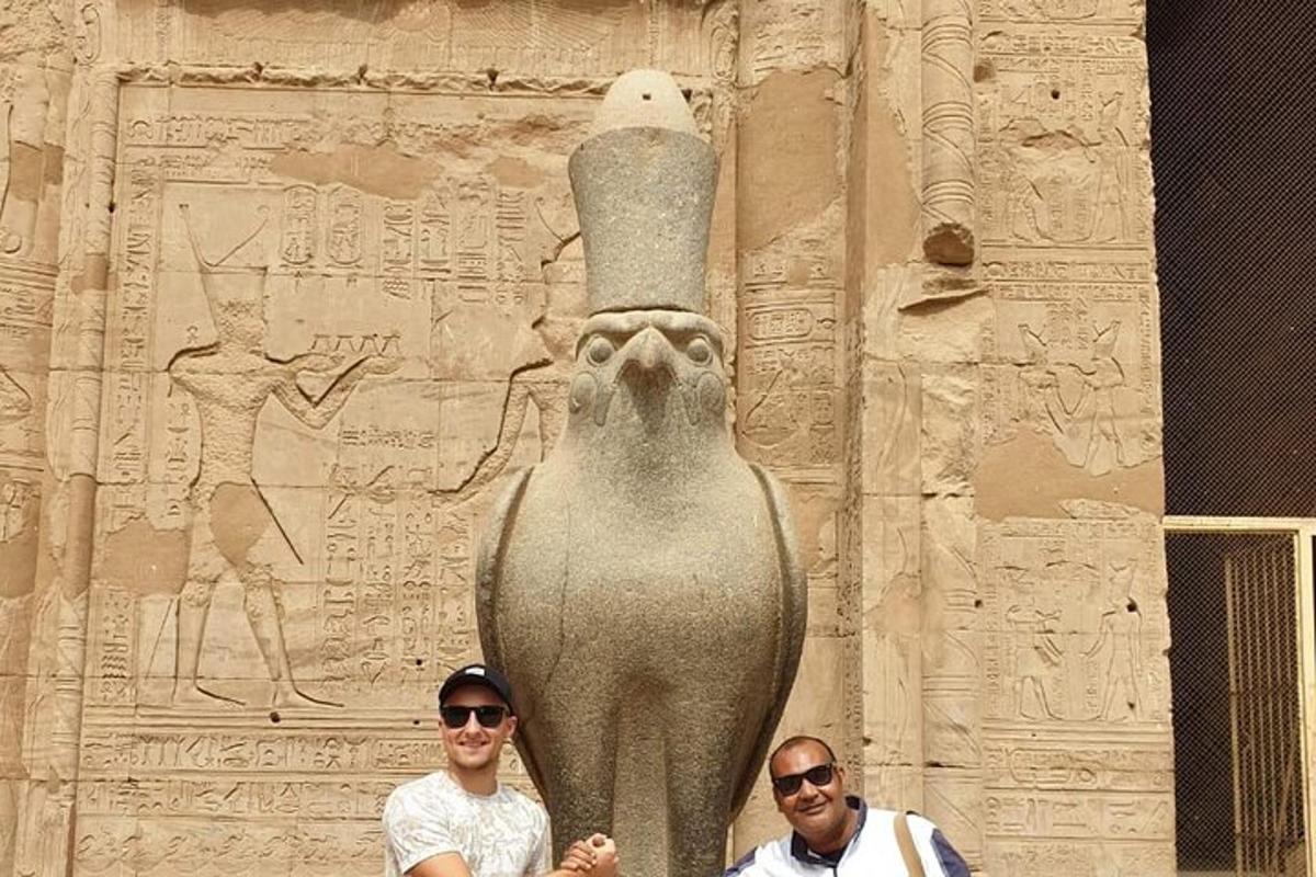 two men standing next to a statue of an elephant