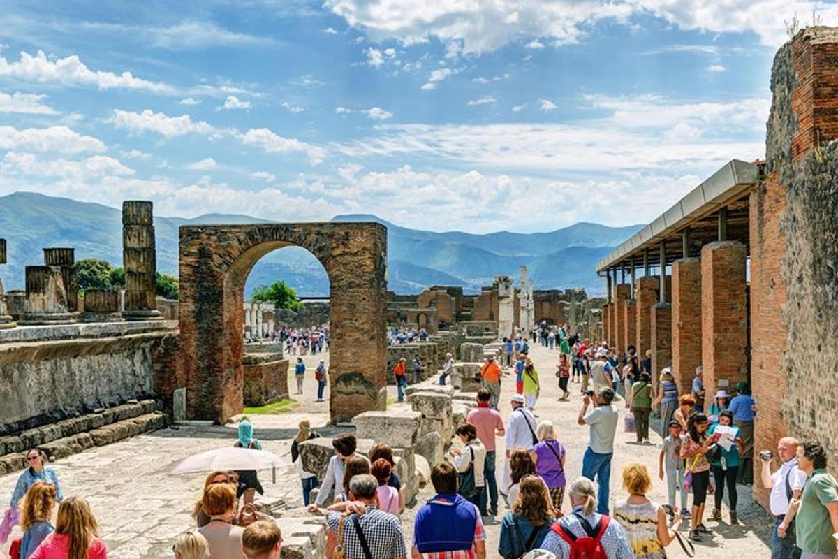 Una multitud de personas caminando alrededor de las ruinas.