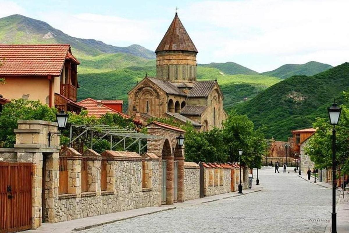 una strada in una città con una chiesa e delle montagne