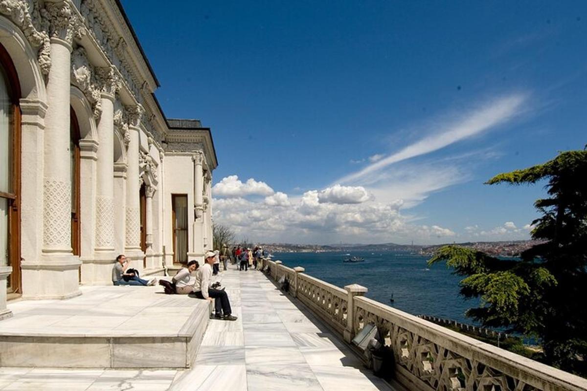 a group of people sitting on a walkway near the water