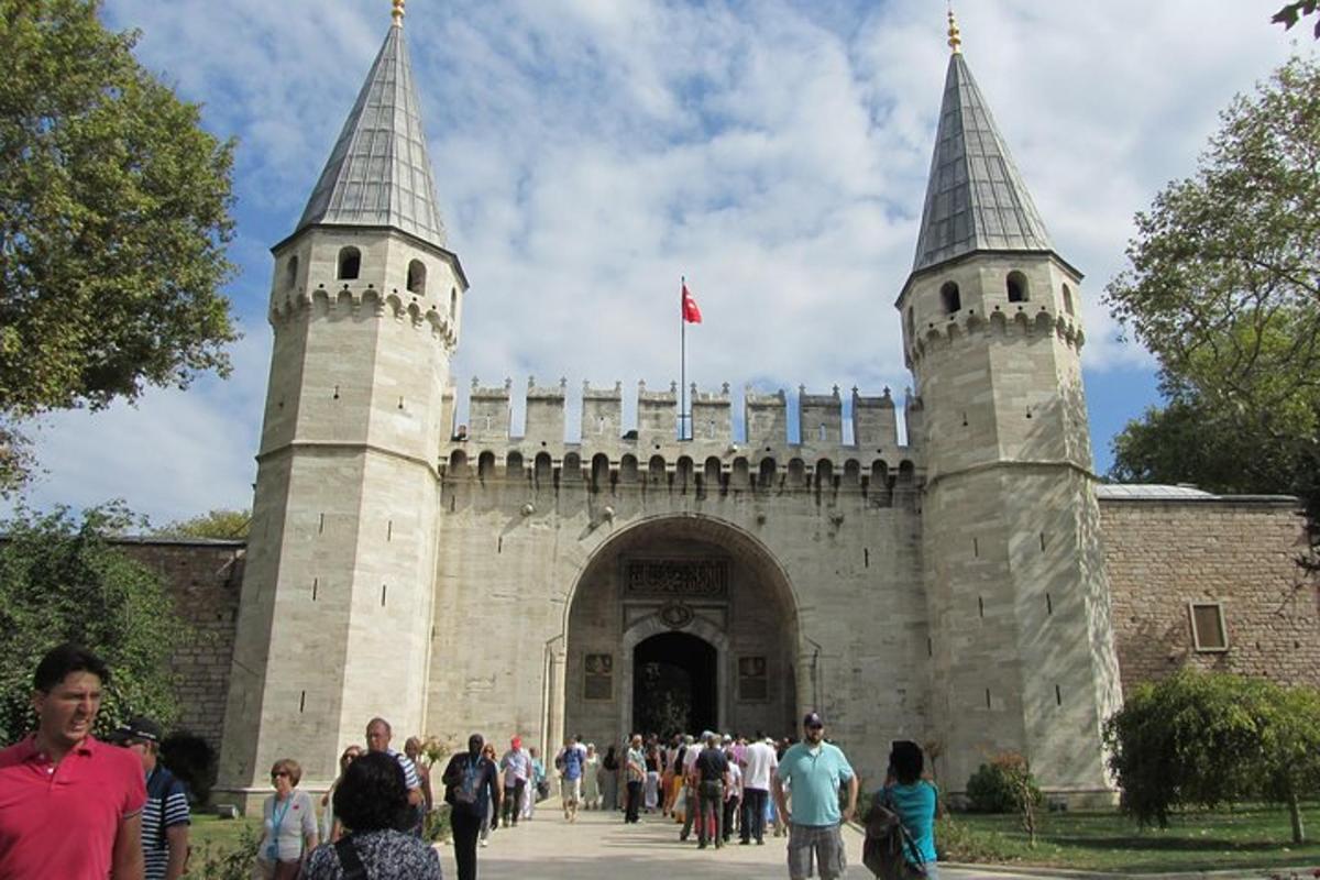 a group of people walking around a building with two towers