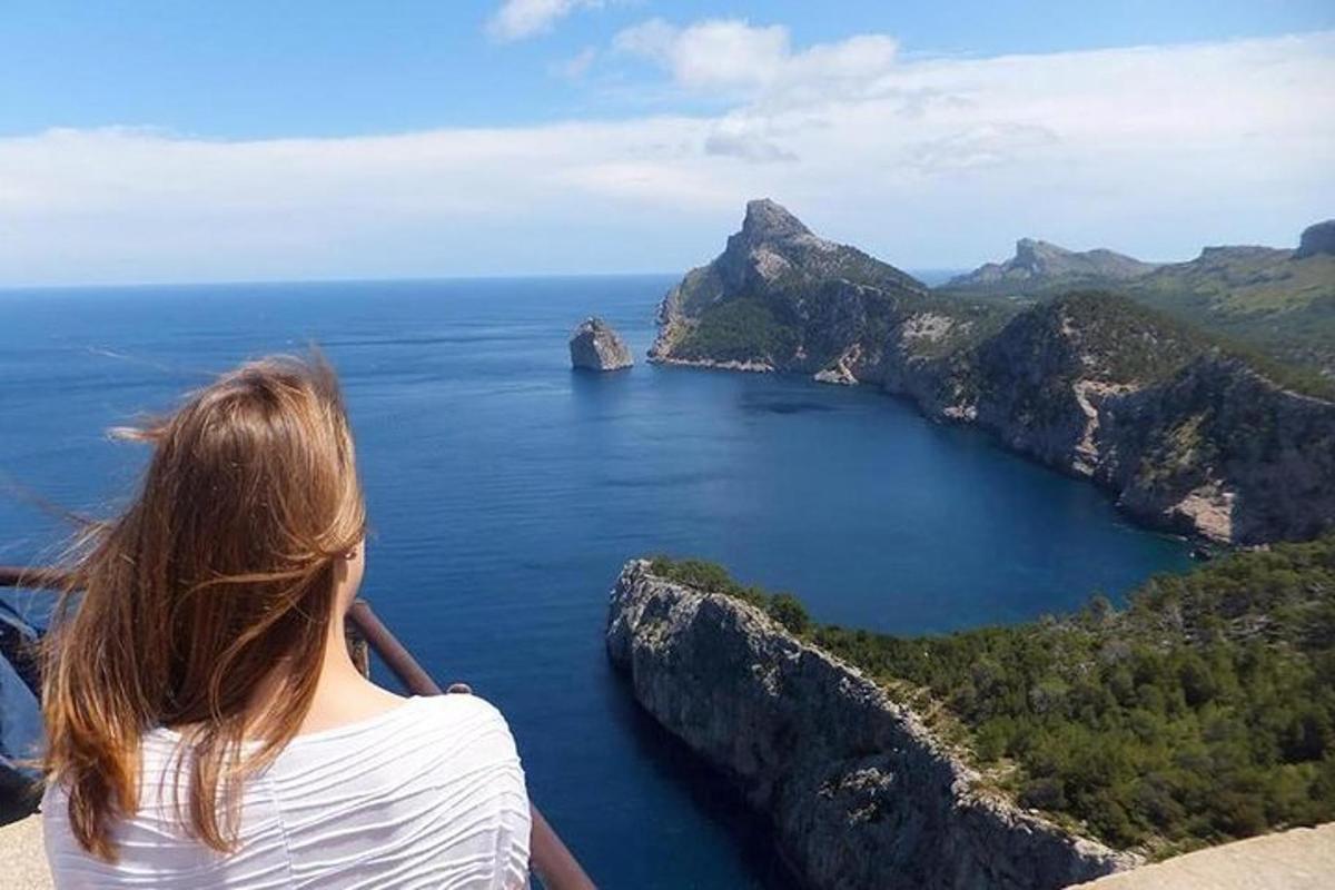 una donna in piedi su una scogliera che guarda l'oceano