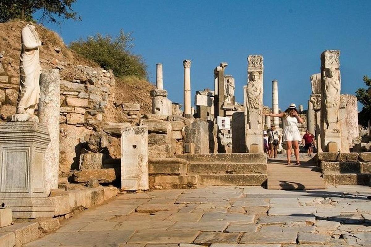 a woman taking a picture of an ancient ruins
