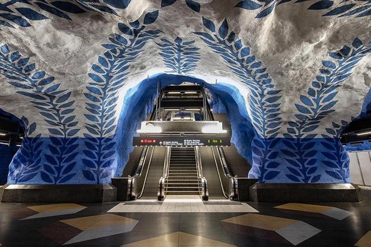 an empty escalator in a subway station with blue painted walls
