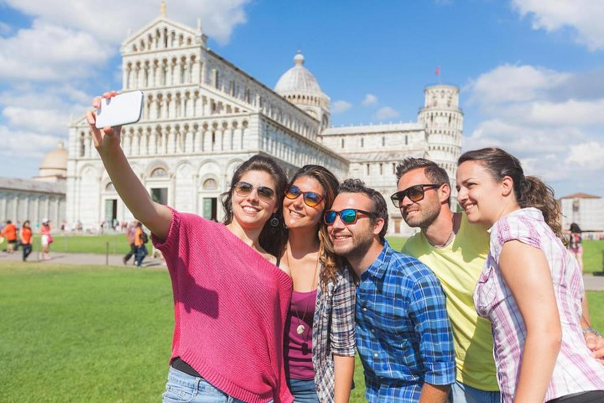 um grupo de pessoas tirando uma foto em frente à torre inclinada