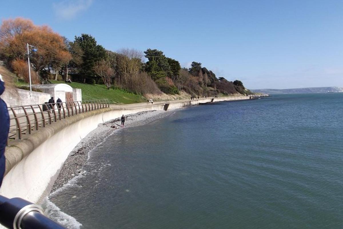 uno specchio d'acqua con persone che camminano sulla spiaggia