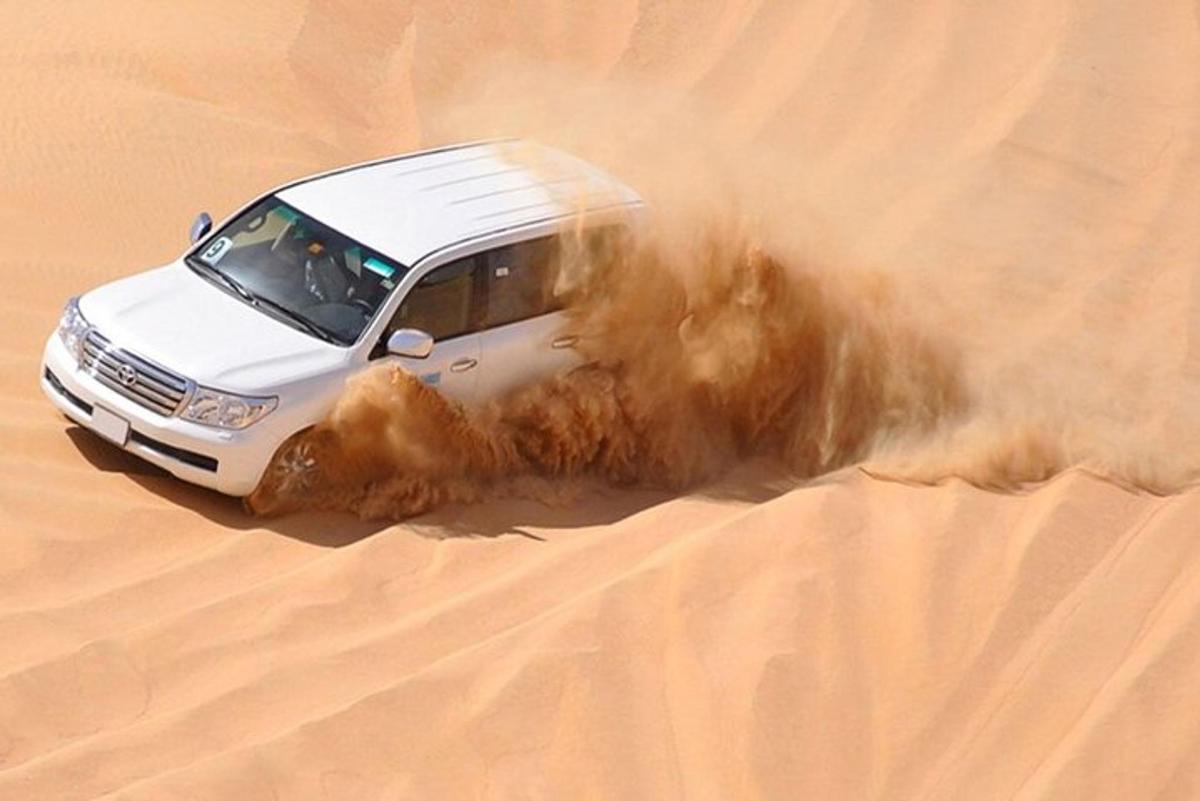 a white car driving through the sand in the desert