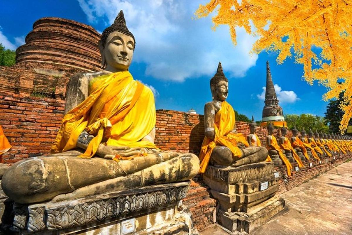 a row of statues sitting on a brick wall