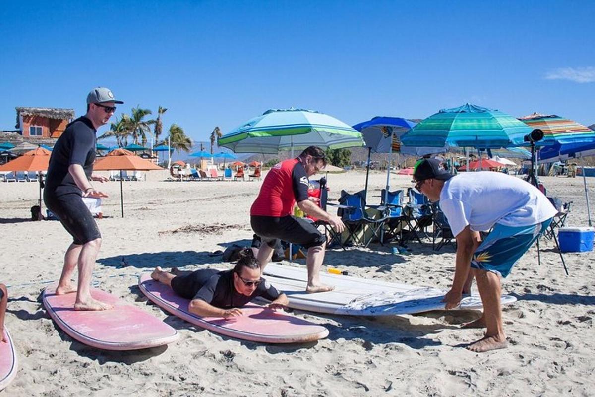 Un grupo de personas de pie sobre tablas de surf en la playa.