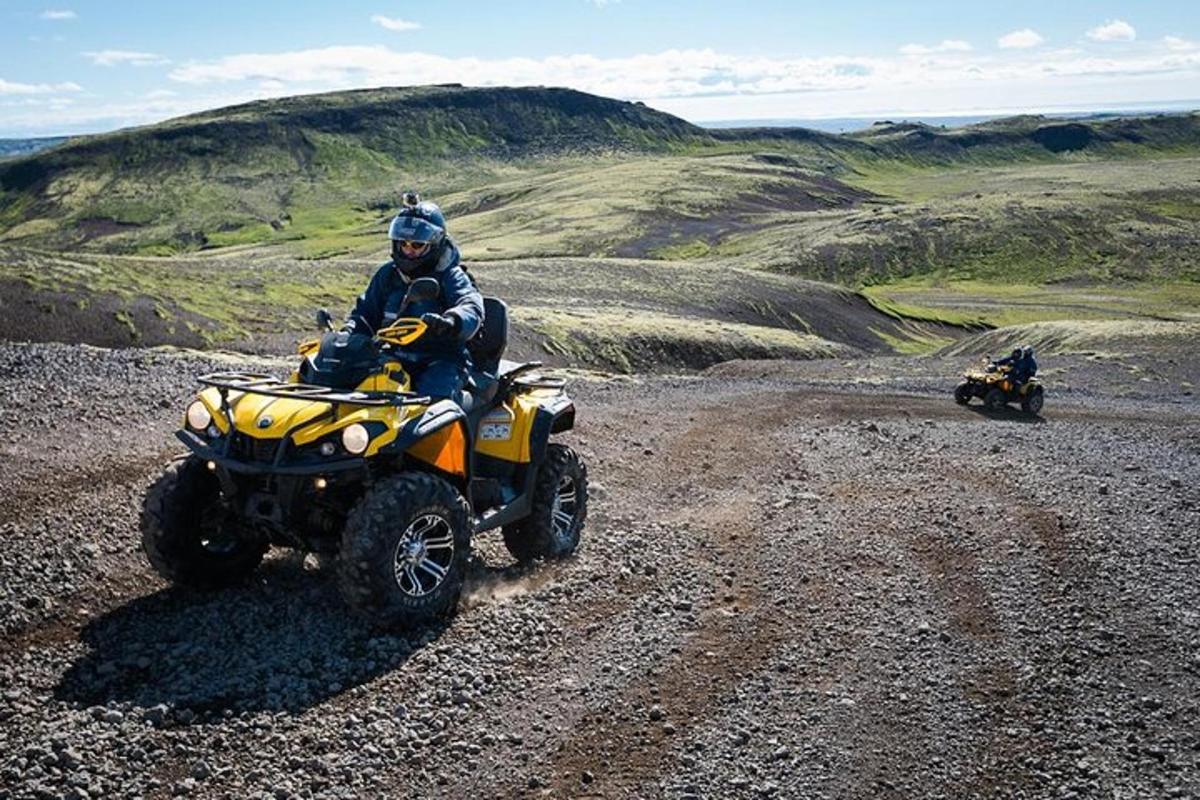 a man riding a four wheeler on a dirt road