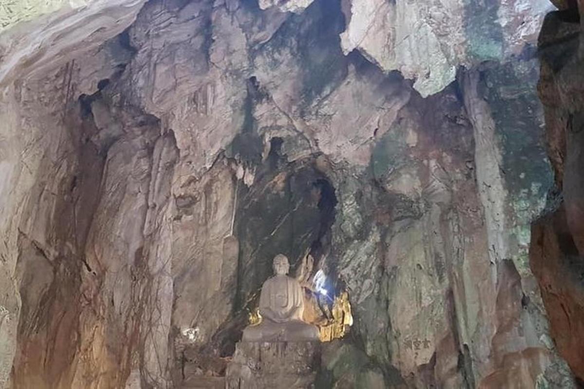 o statuie într-o peșteră cu o persoană în ea