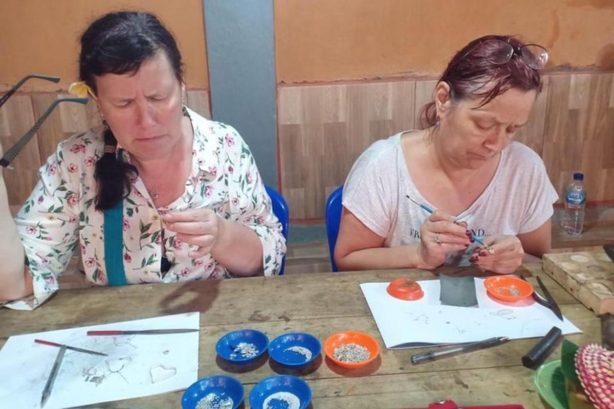 two women sitting at a table with art supplies