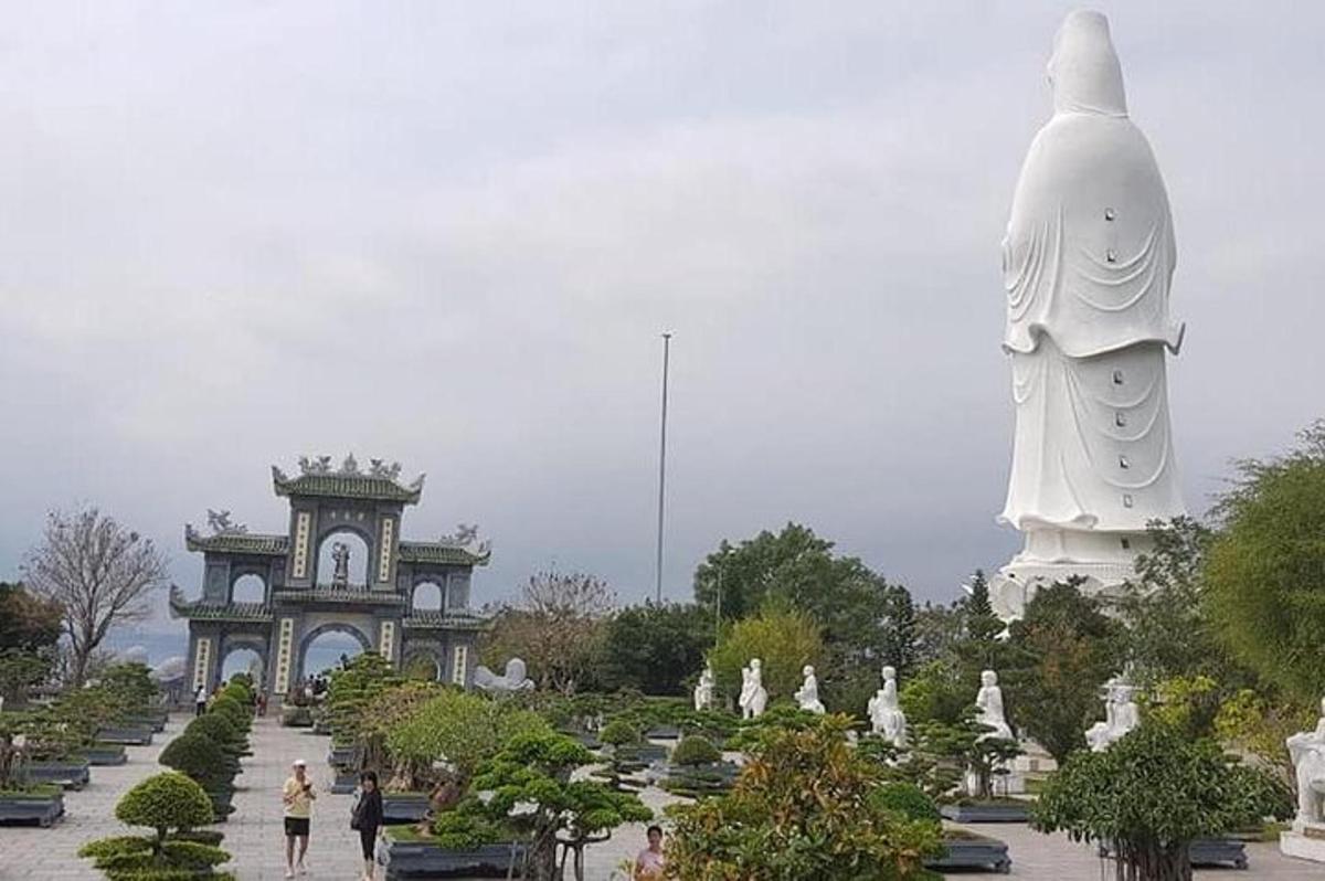 una grande statua in un parco con persone che camminano intorno
