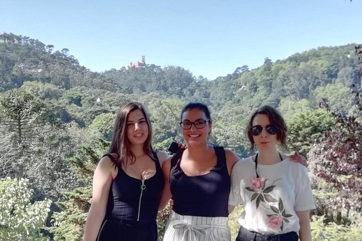tre donne posano per una foto davanti a una montagna