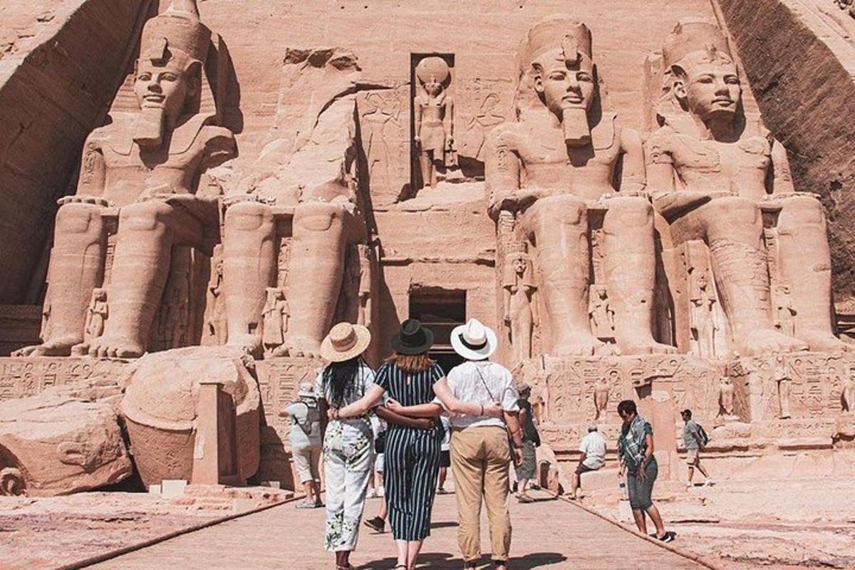 um grupo de pessoas caminhando em frente a uma estátua