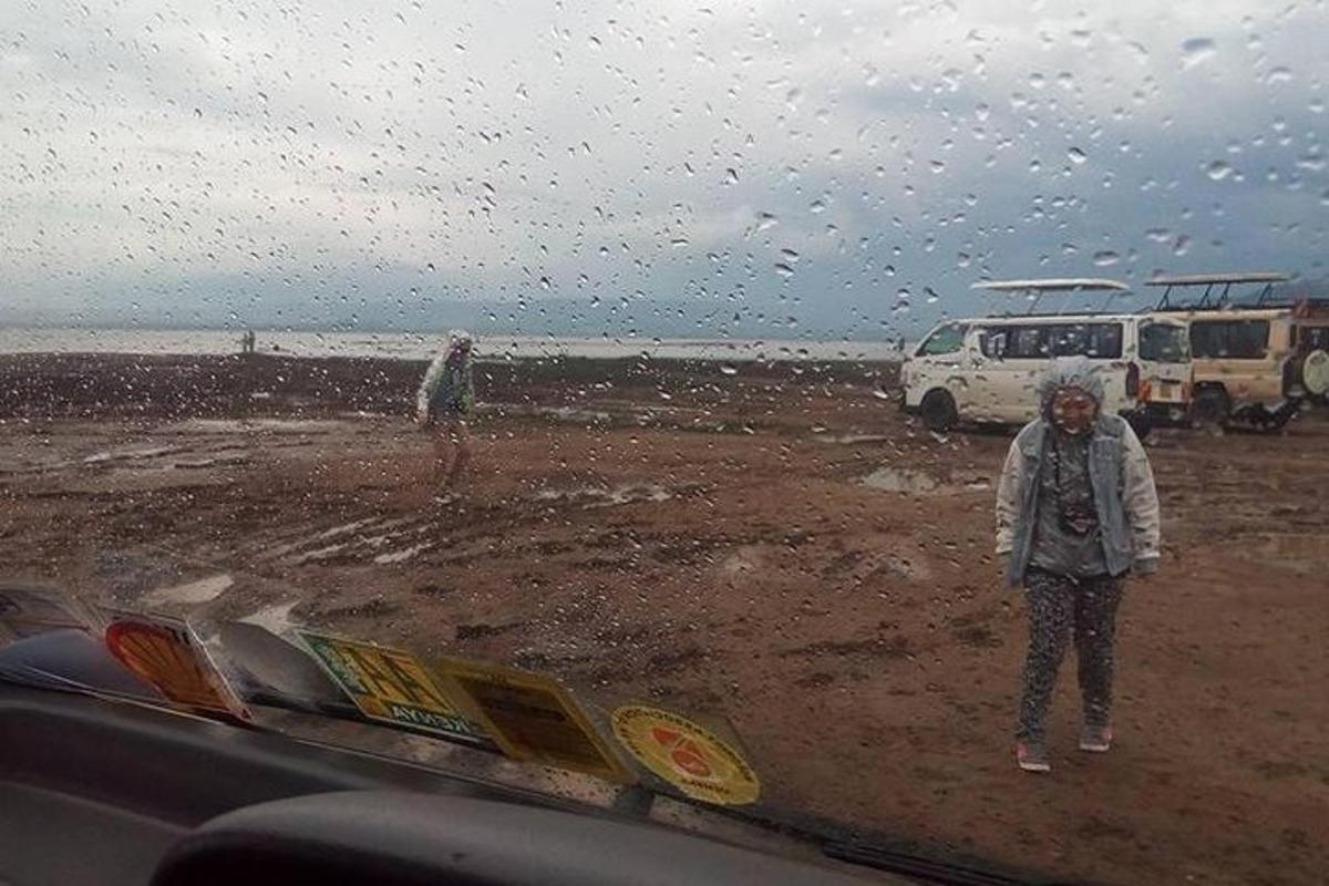dvoje ljudi stoje na plaži na kiši