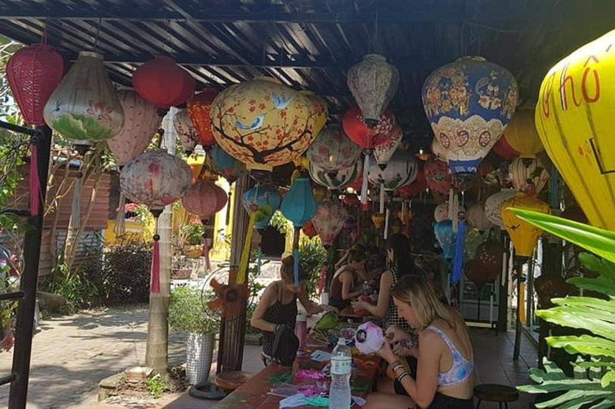 skupina lidí sedících u stolu s lucernami