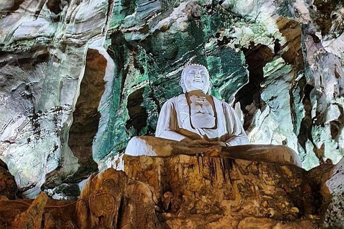 patung yang duduk di atas batu di dalam gua
