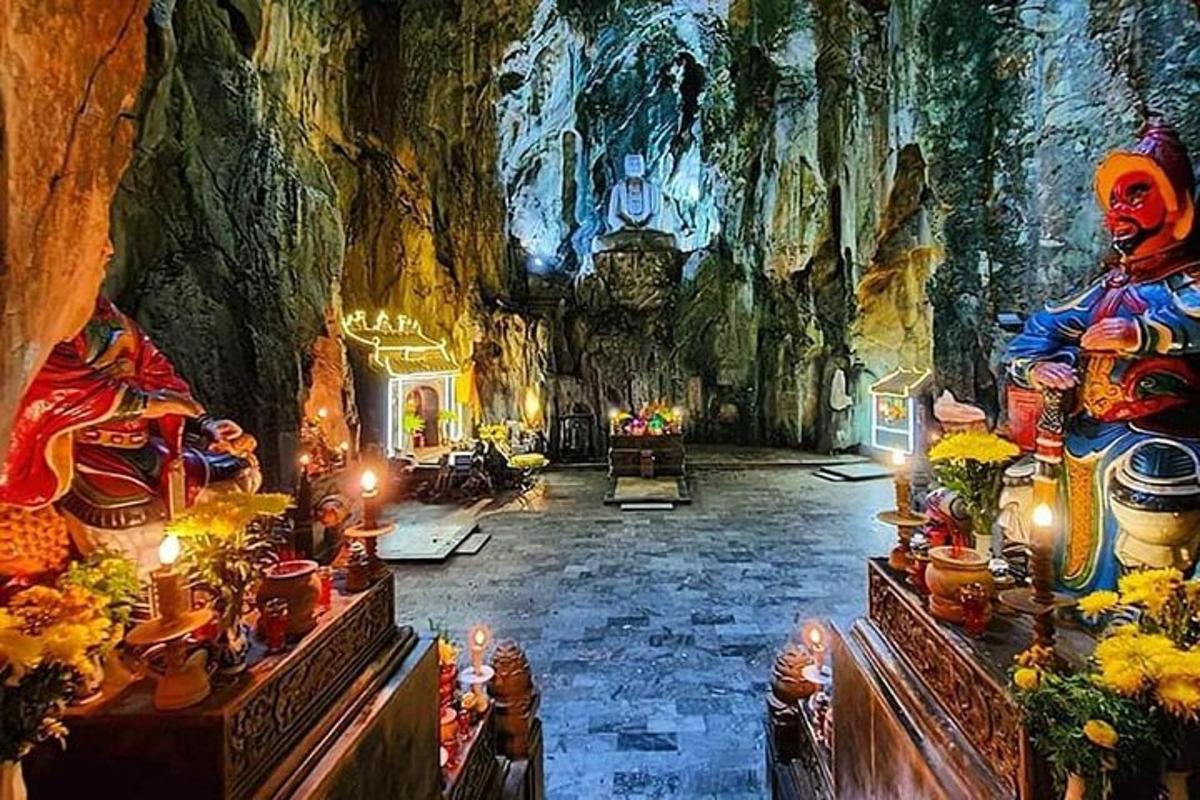một căn phòng lớn có tượng và đèn trong hang động