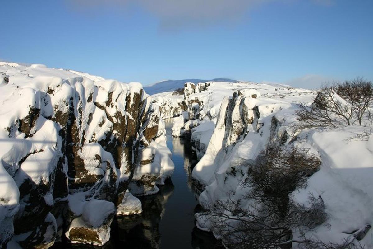 una montaña cubierta de nieve con un cuerpo de agua