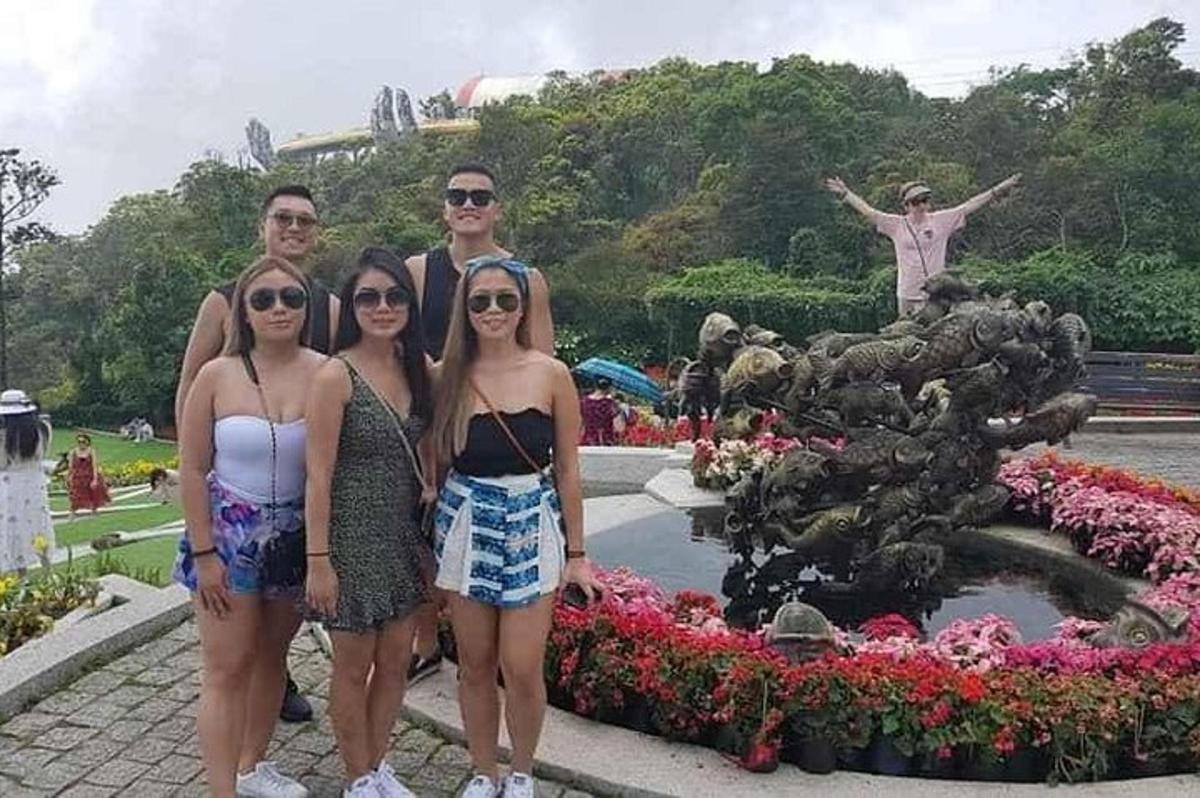 a group of people standing in front of a fountain