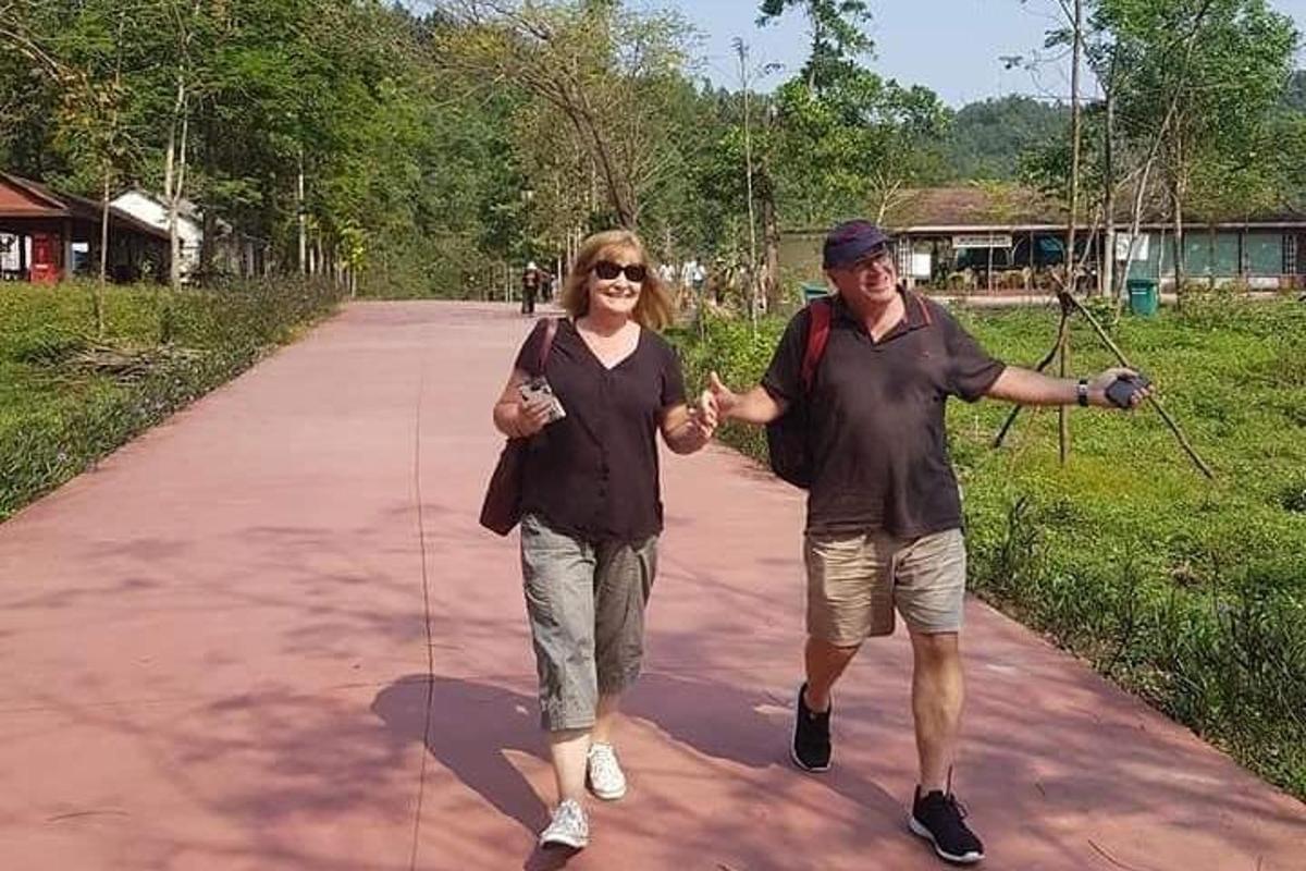 muškarac i žena drže se za ruke dok hodaju stazom