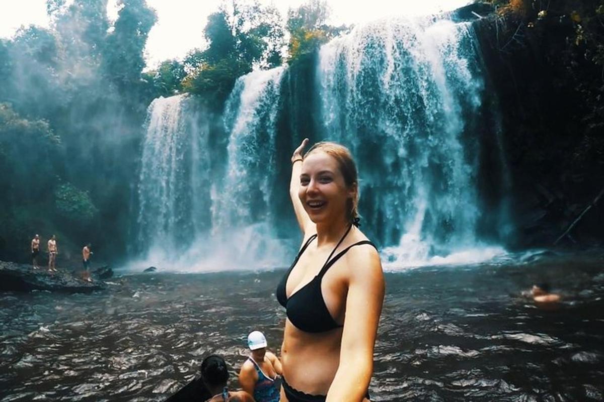 una dona dempeus davant d'una cascada