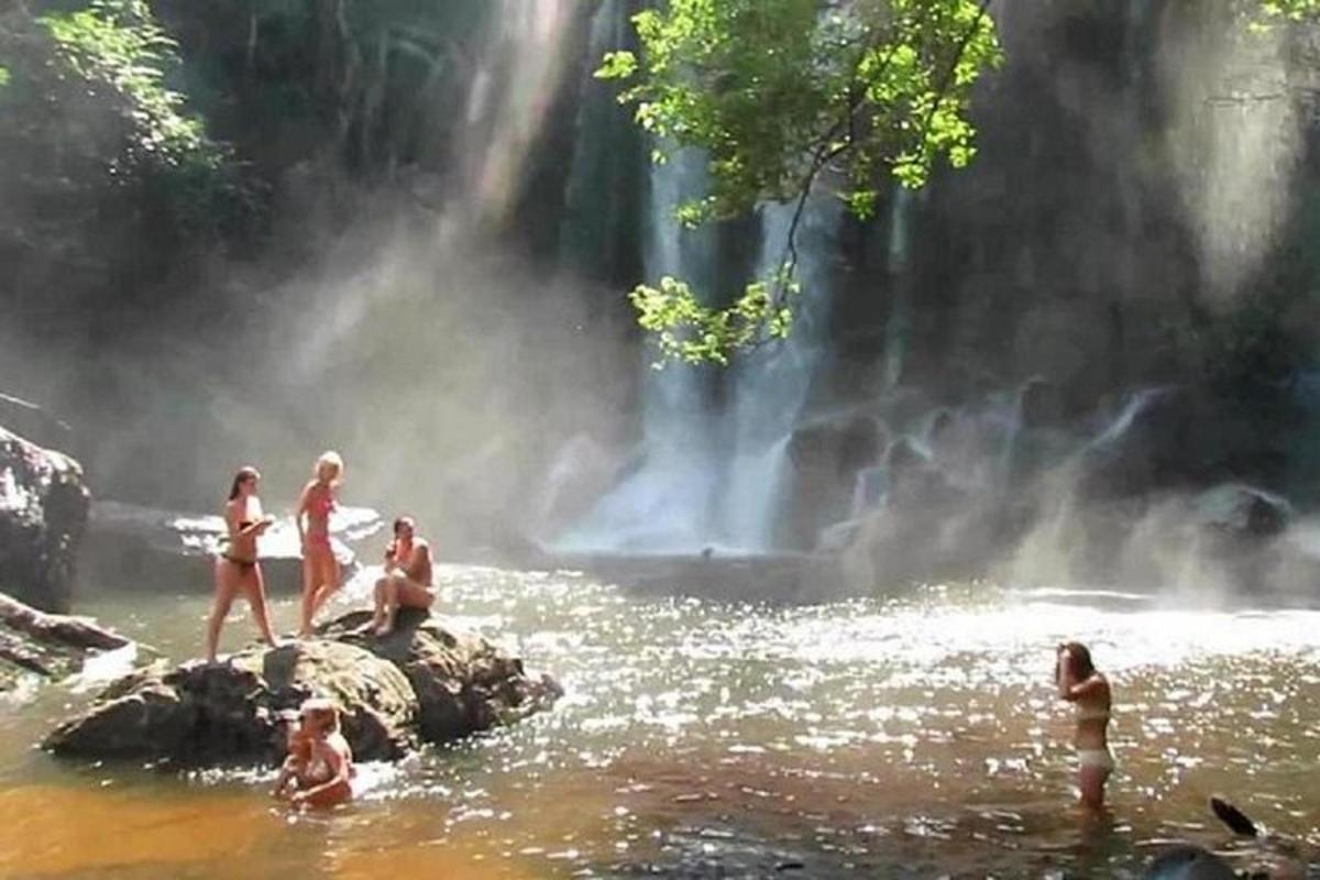 un grup de persones a l'aigua prop d'una cascada