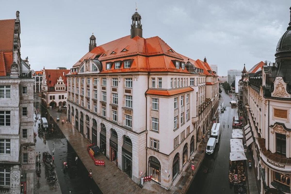 Velká bílá budova s oranžovou střechou na ulici