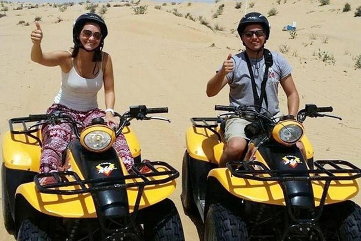 mees ja naine istuvad liival ATV-del