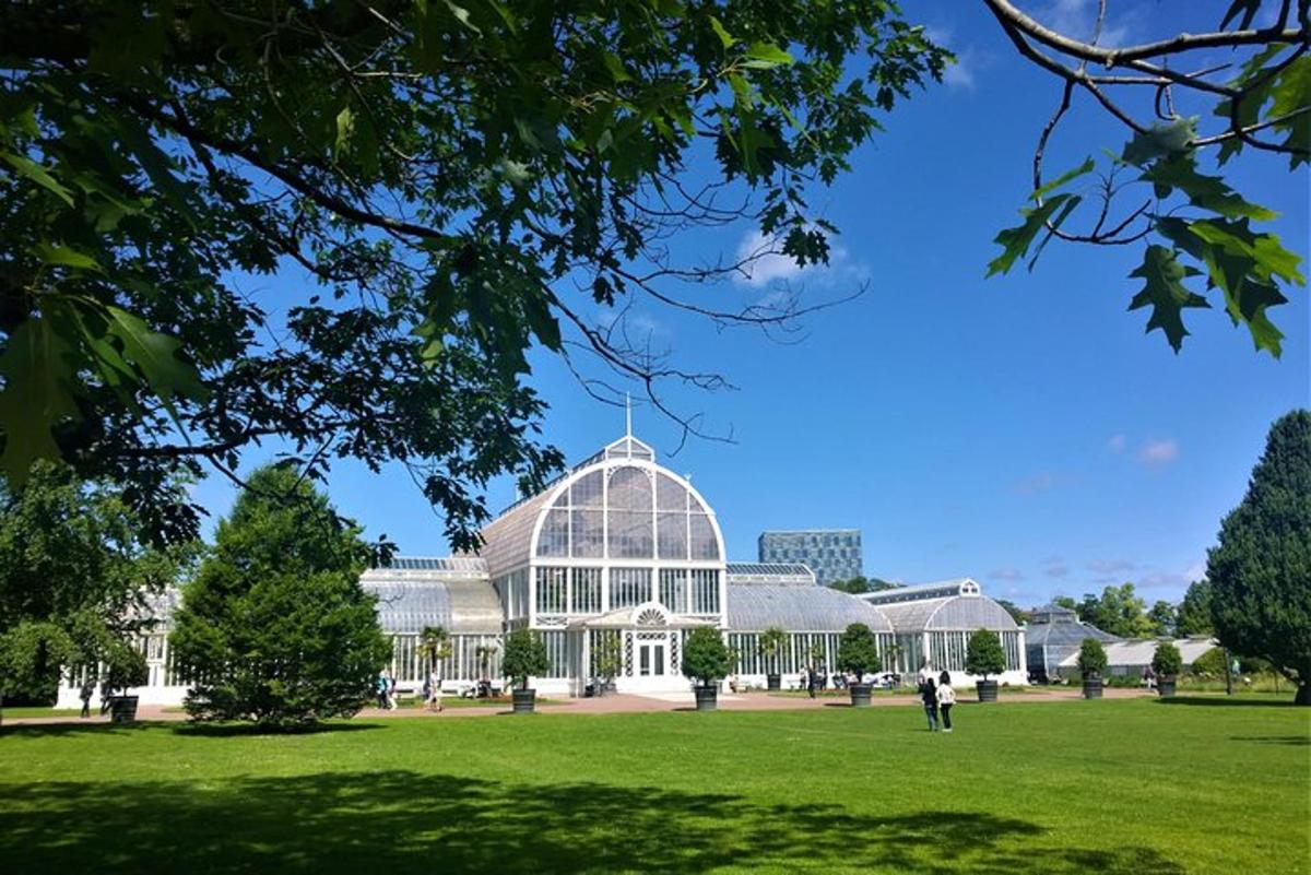 a glass house in a park with a green field