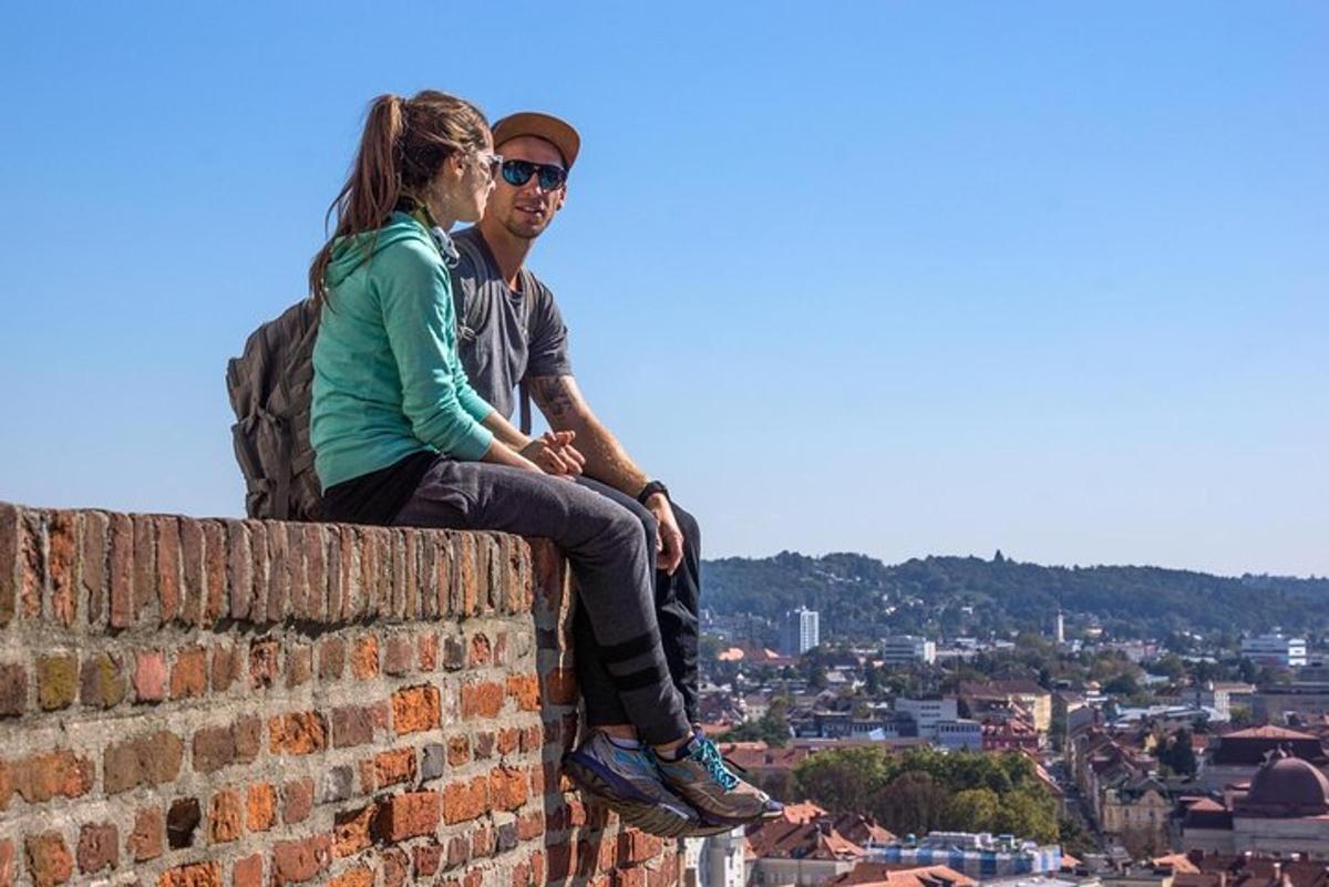 a man and a woman sitting on top of a brick wall