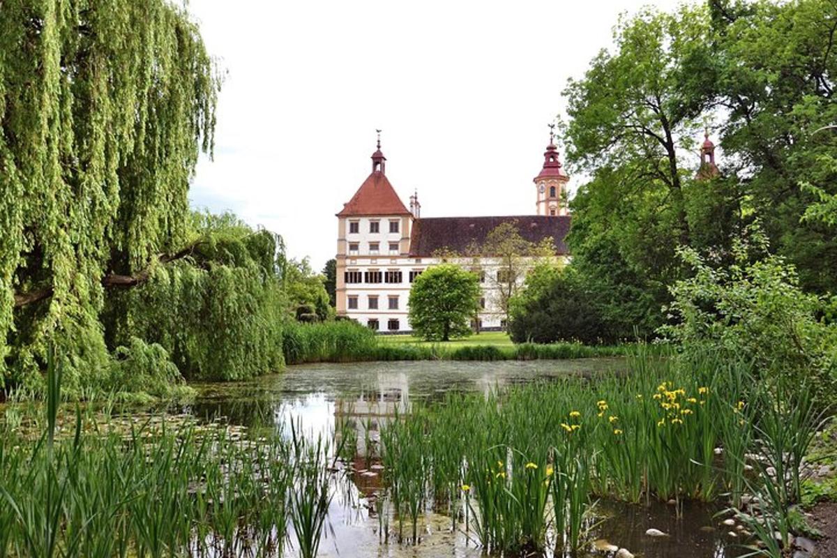 a building in the middle of a lake with trees and plants