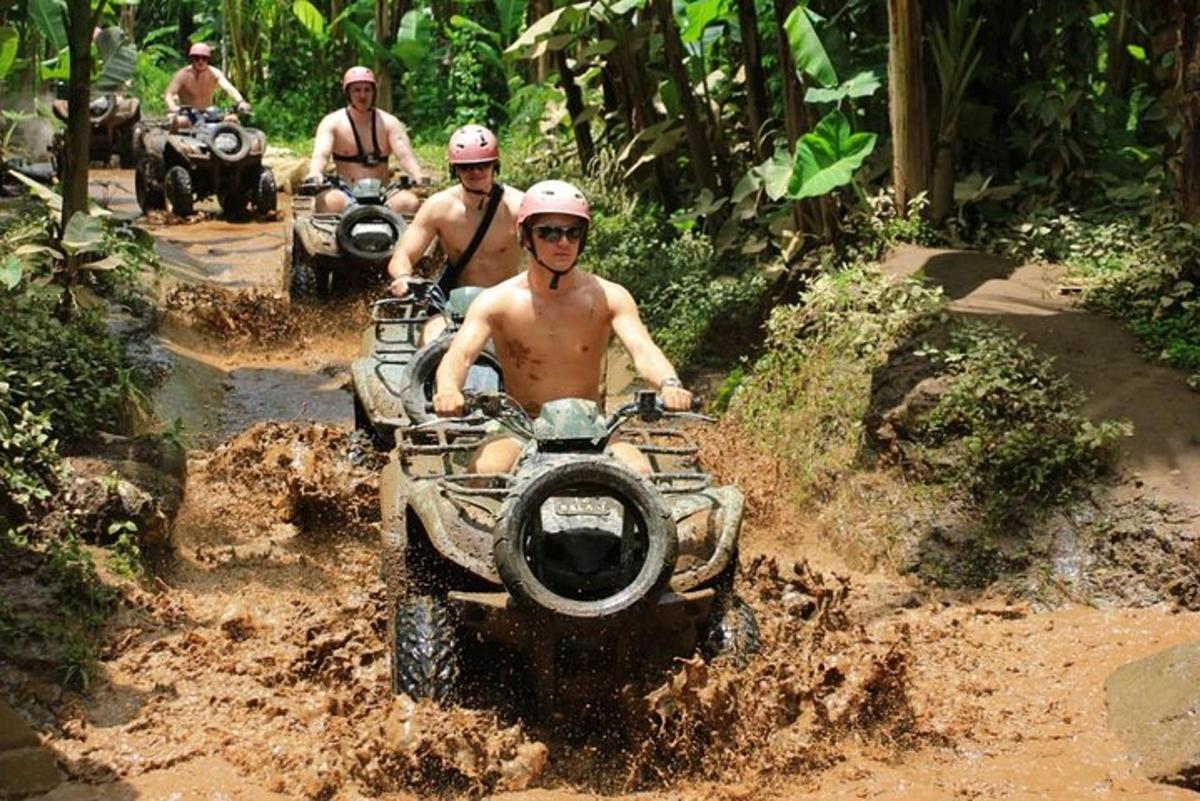 một nhóm đàn ông đang đi xe địa hình qua một con đường đất
