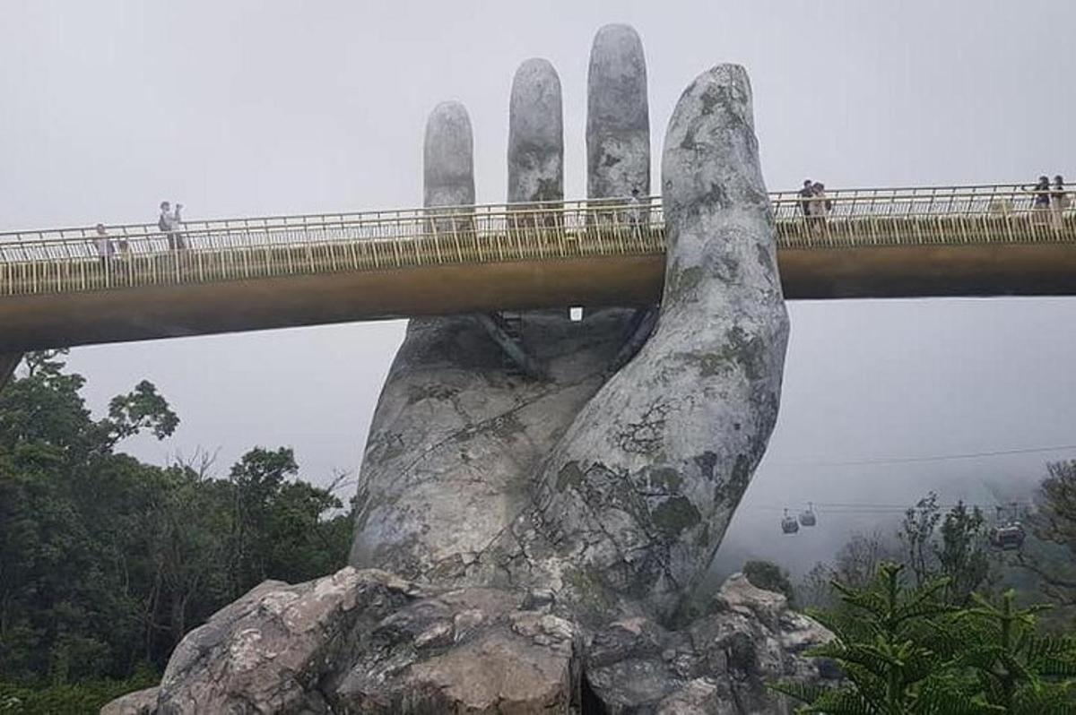 Un puente sobre una roca con una mano de roca gigante.