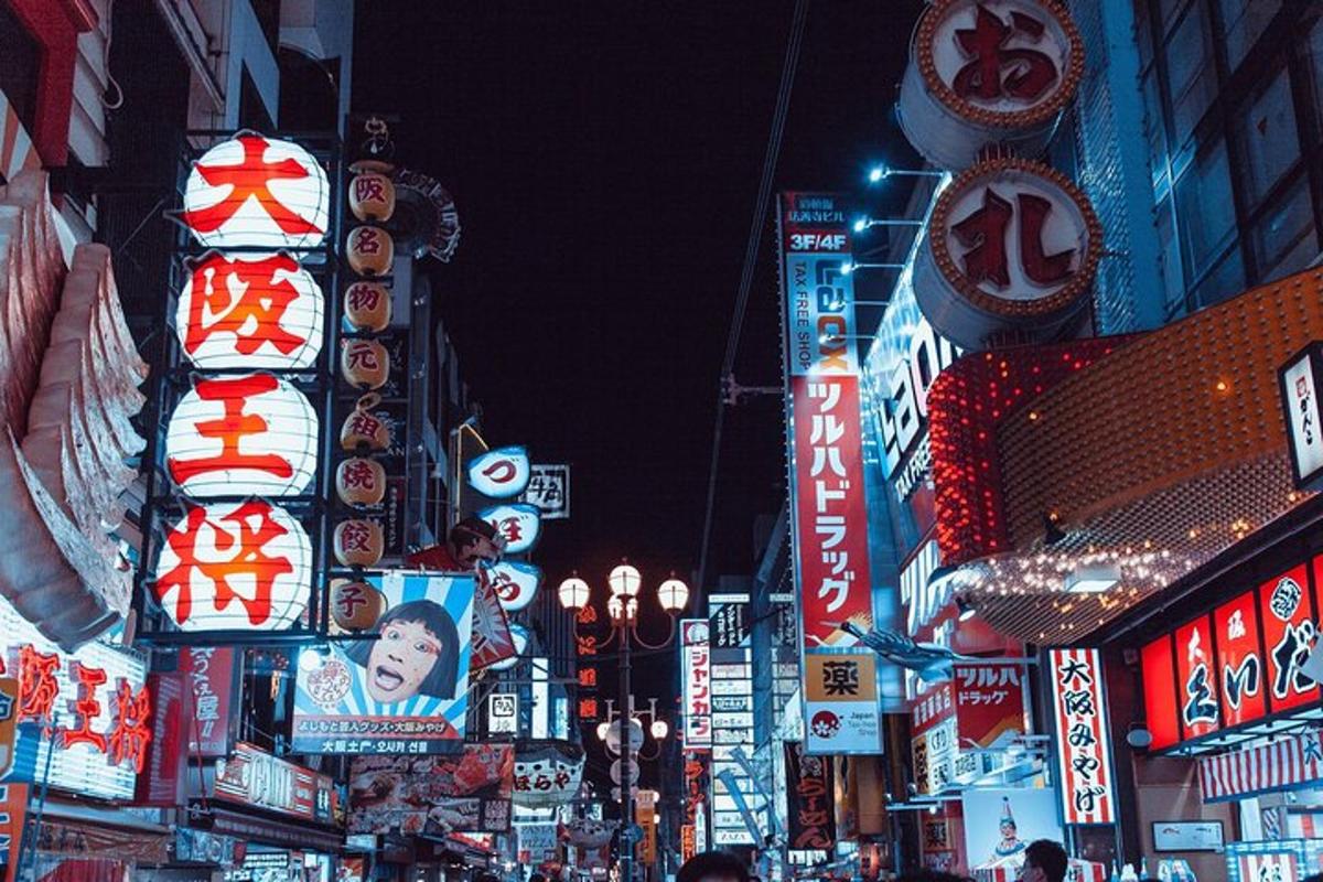 una strada cittadina trafficata di notte con insegne al neon