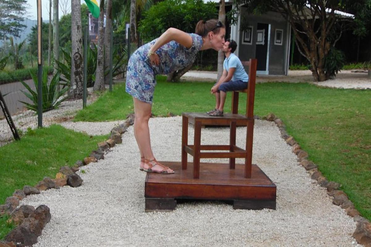 a woman standing next to a man sitting on a chair