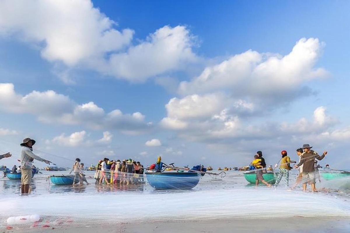 um grupo de pessoas em uma praia com barcos