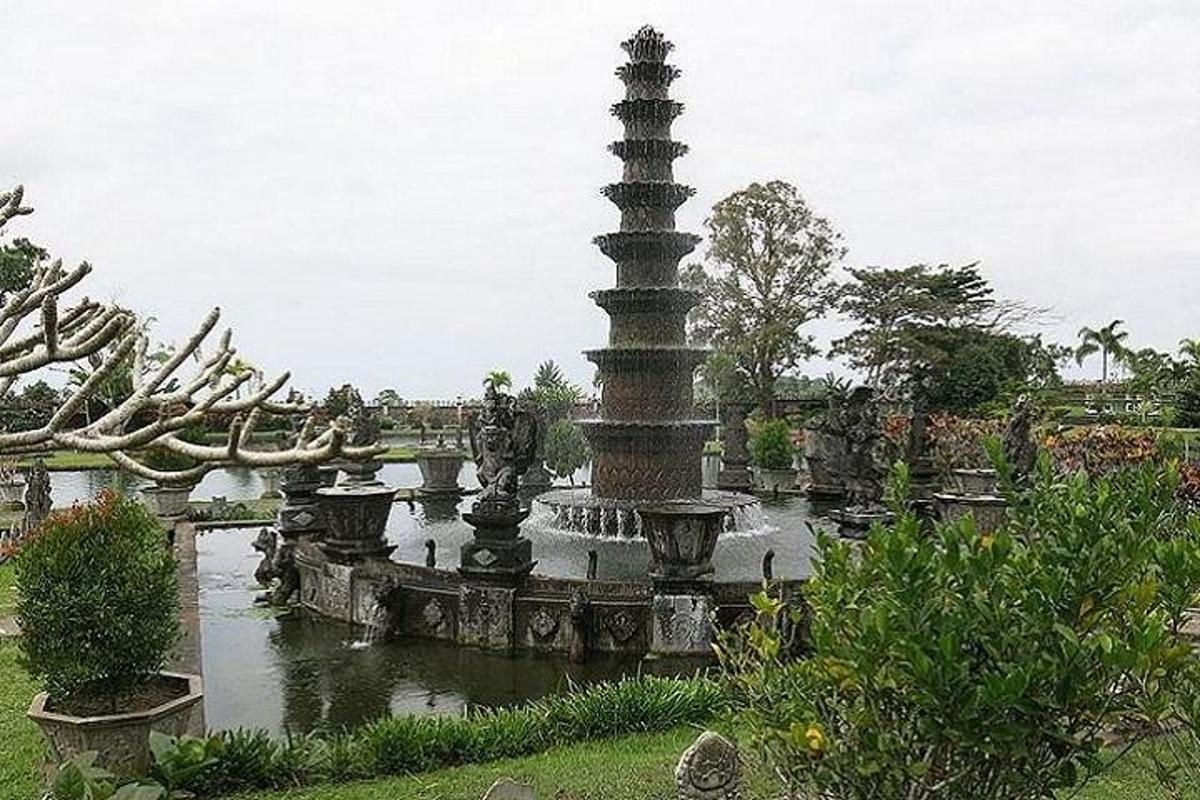 Una fuente en un jardín con un poste en el agua.