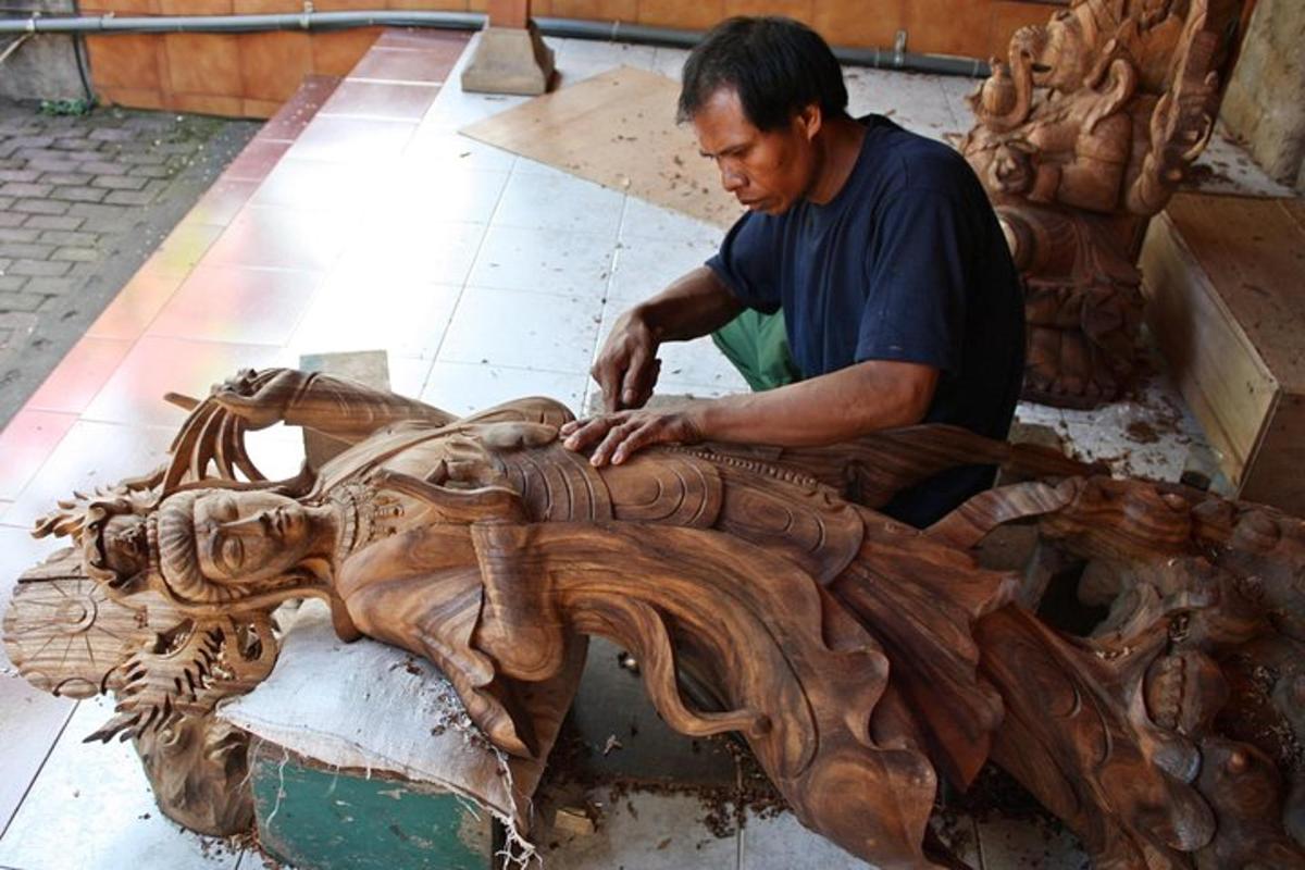 un home treballant en una escultura de fusta d'un animal