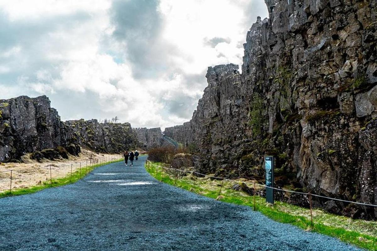 um grupo de pessoas caminhando por uma estrada entre rochas