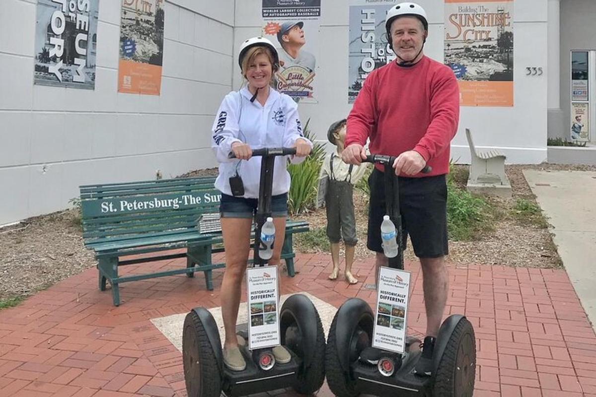 muž a žena stojící vedle dvou segwayů