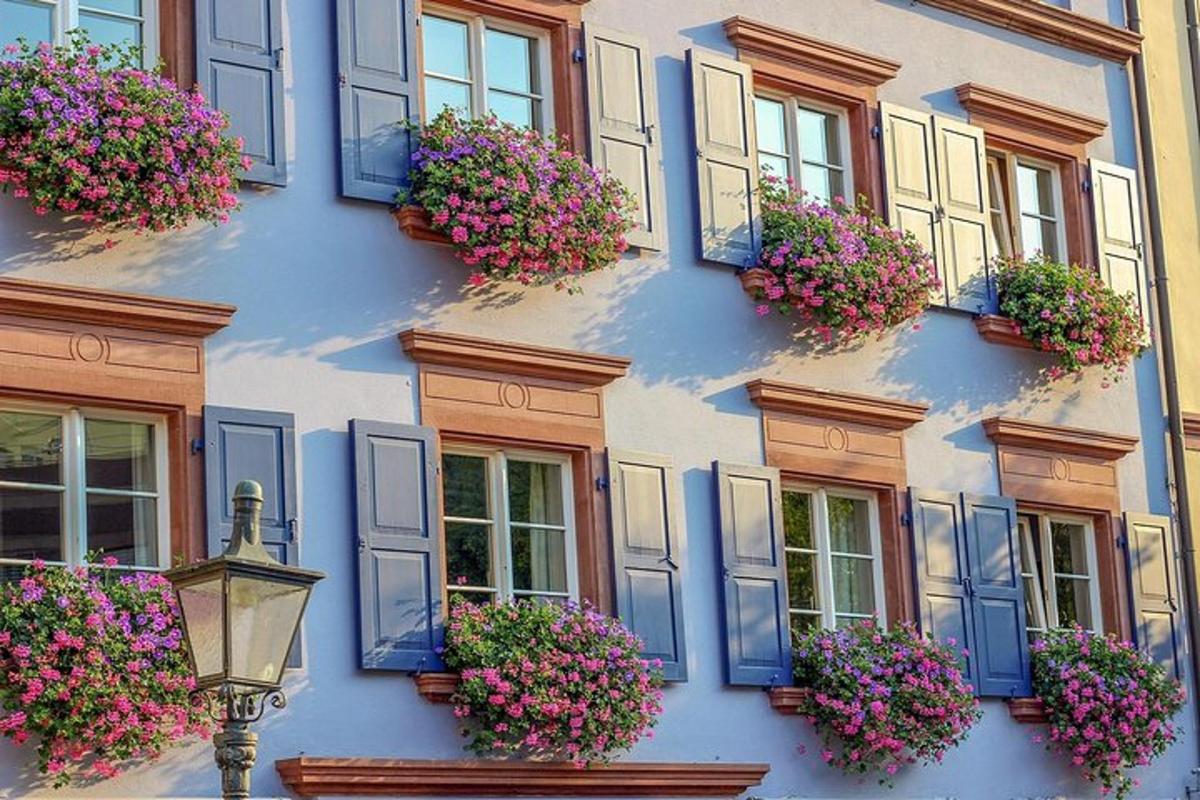 Un edificio con ventanas azules y flores.