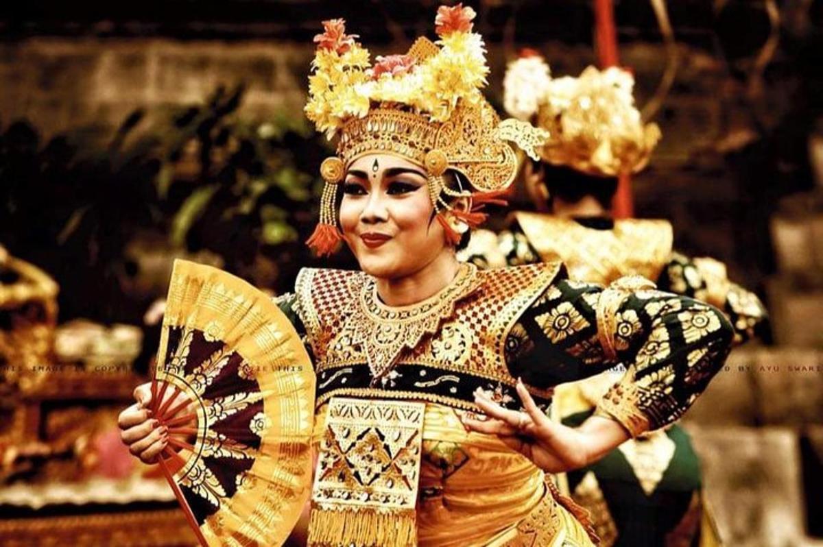 una donna in costume con corona e ventaglio