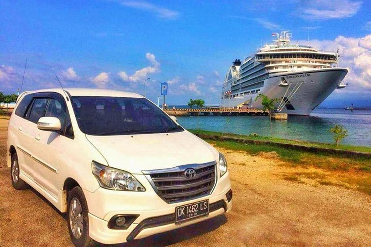 sebuah mobil putih terparkir di depan kapal pesiar