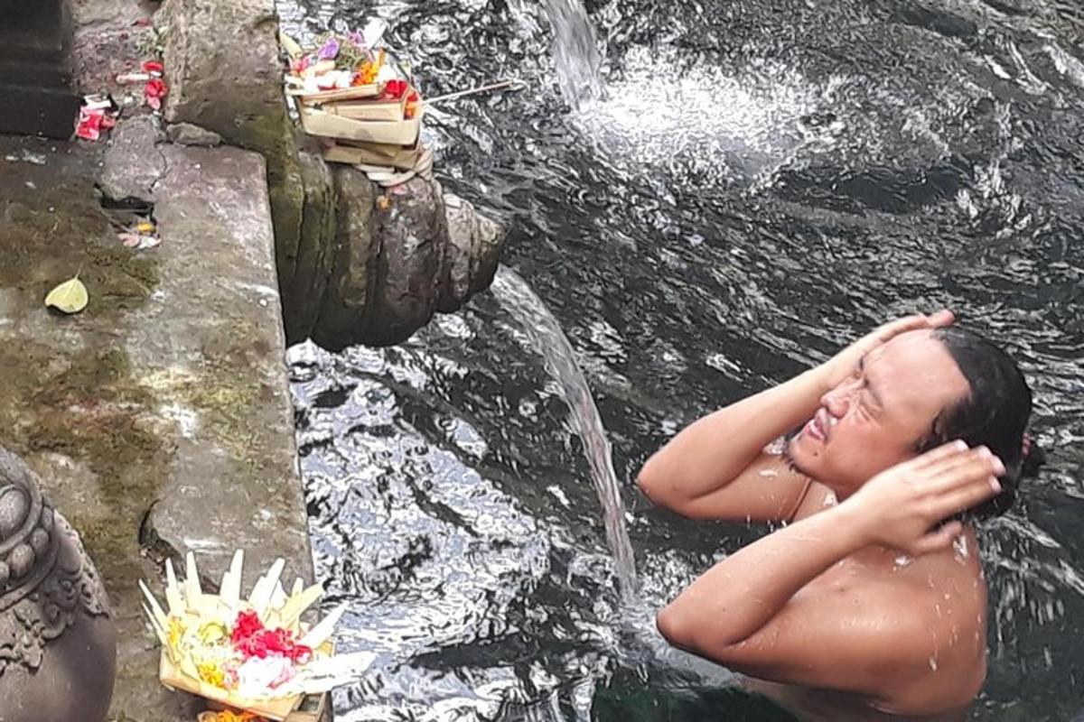 una donna sdraiata nell'acqua accanto a una cascata