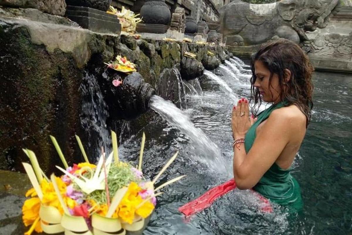 una donna in piedi nell'acqua di fronte a una cascata