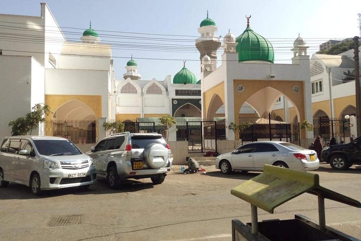 um grupo de carros estacionados em frente a uma mesquita